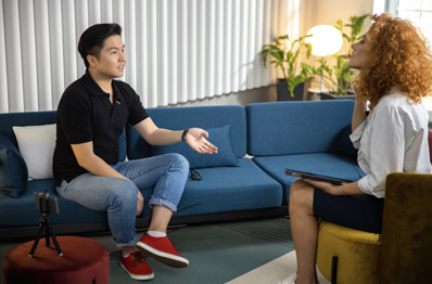 Man speaking to woman on couch